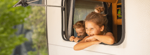 jongen en meisje kijken uit het raam van de caravan
