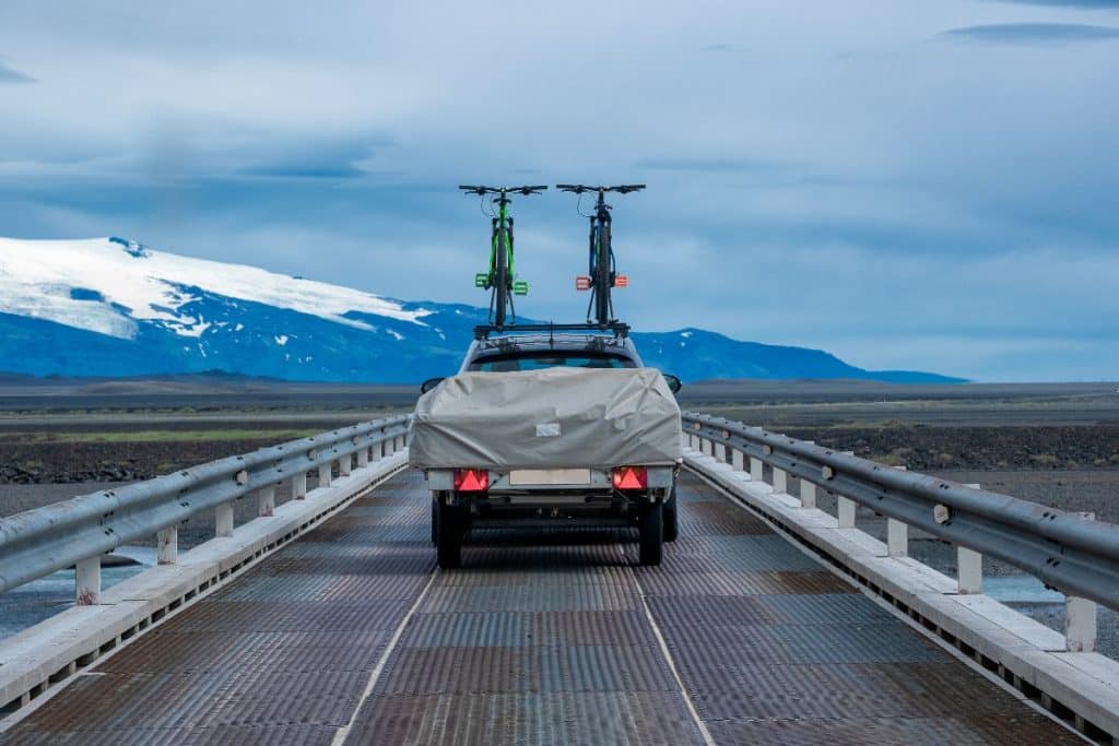 vouwwagen achter de auto op brug in de bergen. bandenspanning voor uw vouwwagen