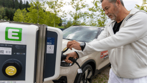 man bij laadpaal elektrische auto