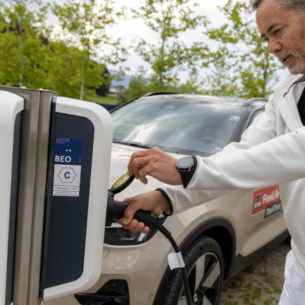 man bij laadpaal elektrische auto