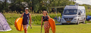 man en vrouw camping met sup en camper. reisverzekering acsi