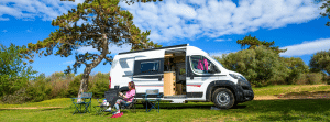 Vrouw voor camper op camping blauwe lucht